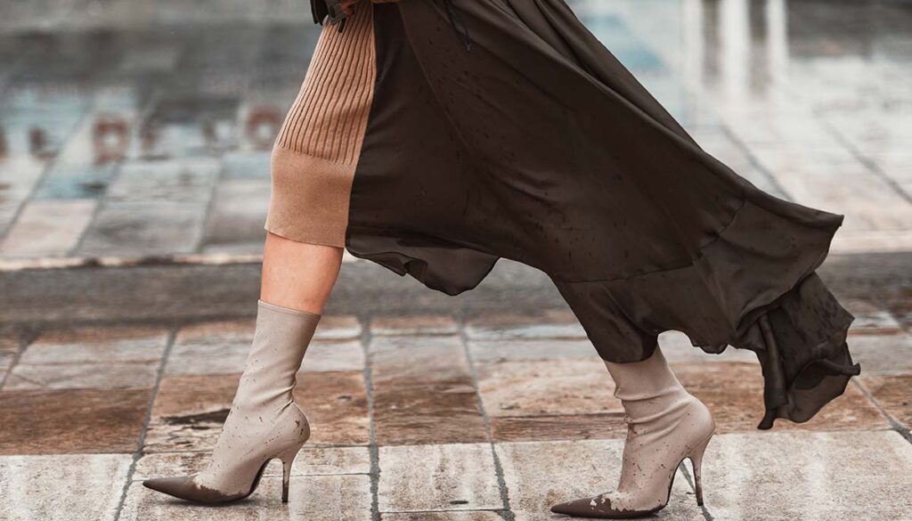 woman walking in layered skirts and pointed high heel boots