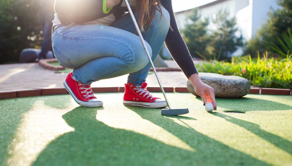 woman playing mini-golf