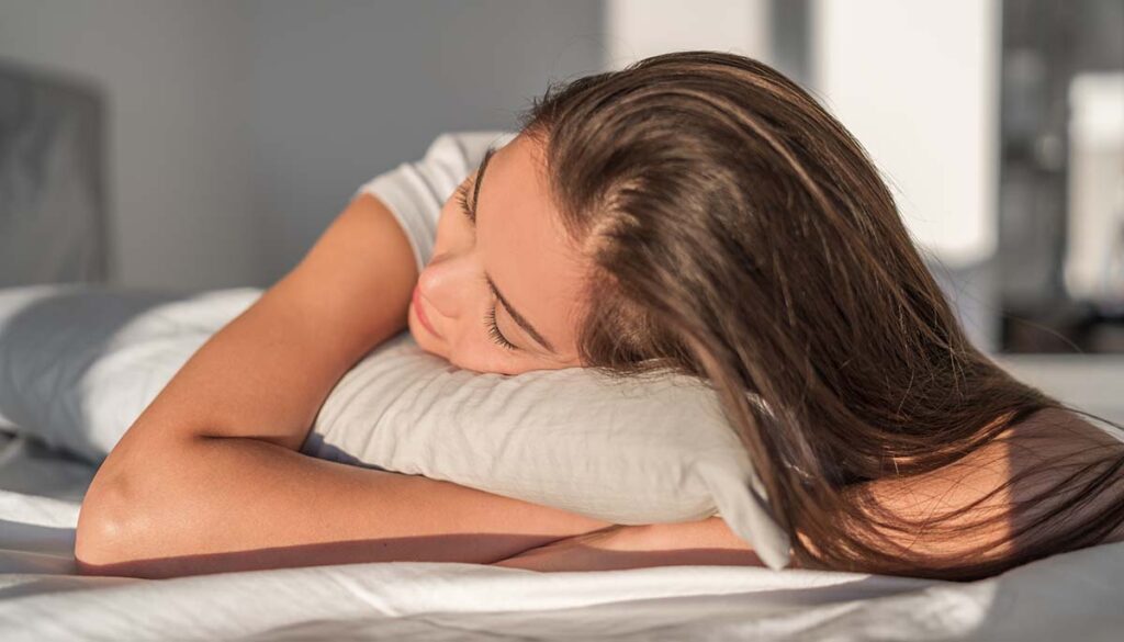 Sleeping on foam pillow bed Asian girl sleeping on stomach sleeper resting head on foam pillow. Hair care silk pillowcase. Good night sleep or midday nap.