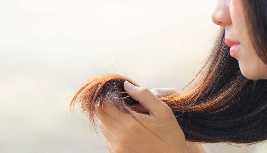 woman examining her hair
