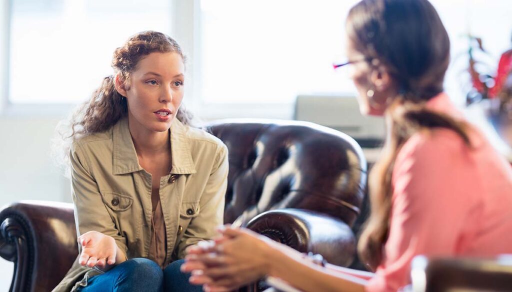 young woman talking to female therapist