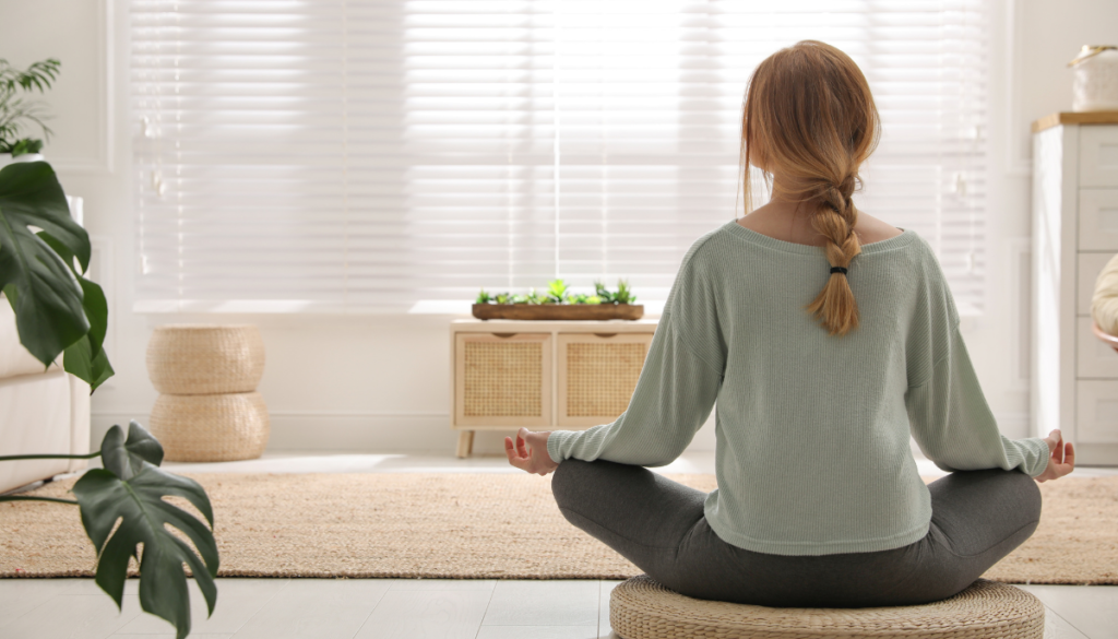 Woman sitting in yoga lotus pose in clean room
