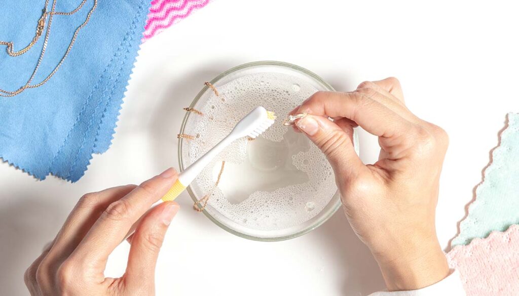 woman's hands cleaning jewelry at home