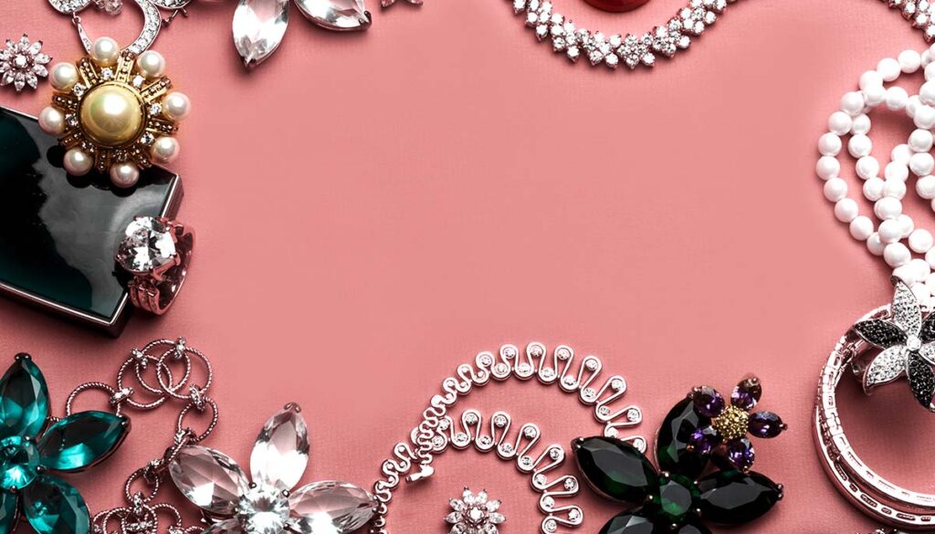 costume jewelry with beautiful stones on pink background
