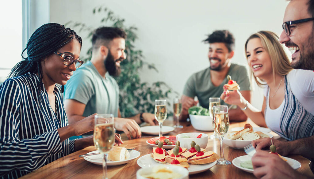 Group Of Happy Young Friends Enjoying Dinner At Home. Group of multiethnic friends enjoying dinner party