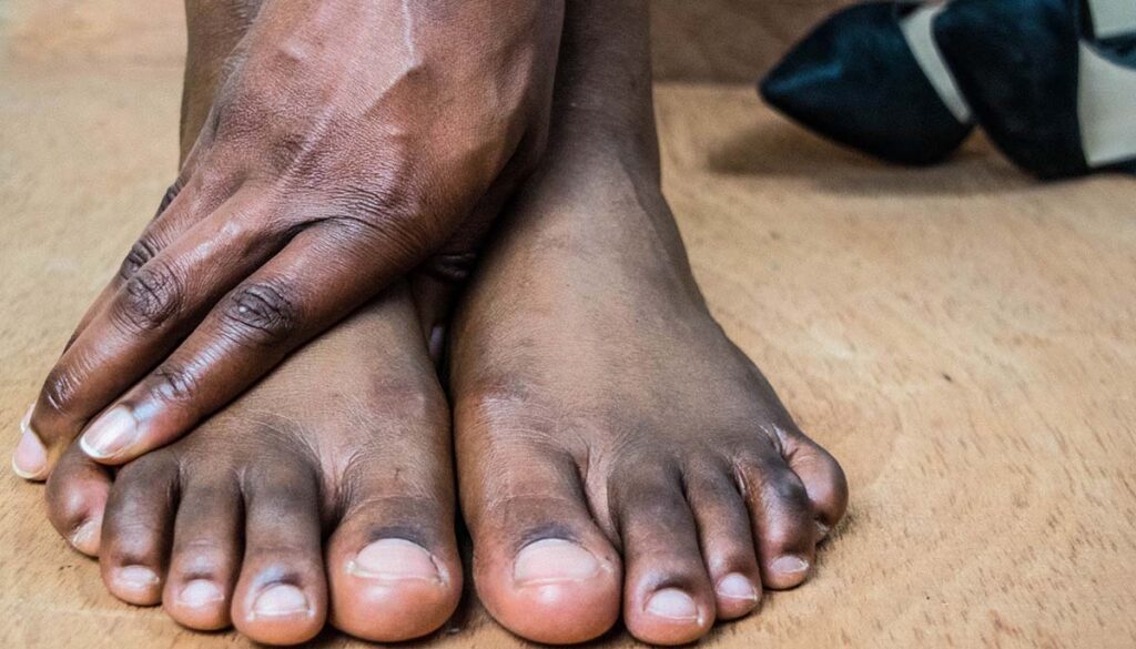 woman bare foot suffering from foot pain after wearing heels