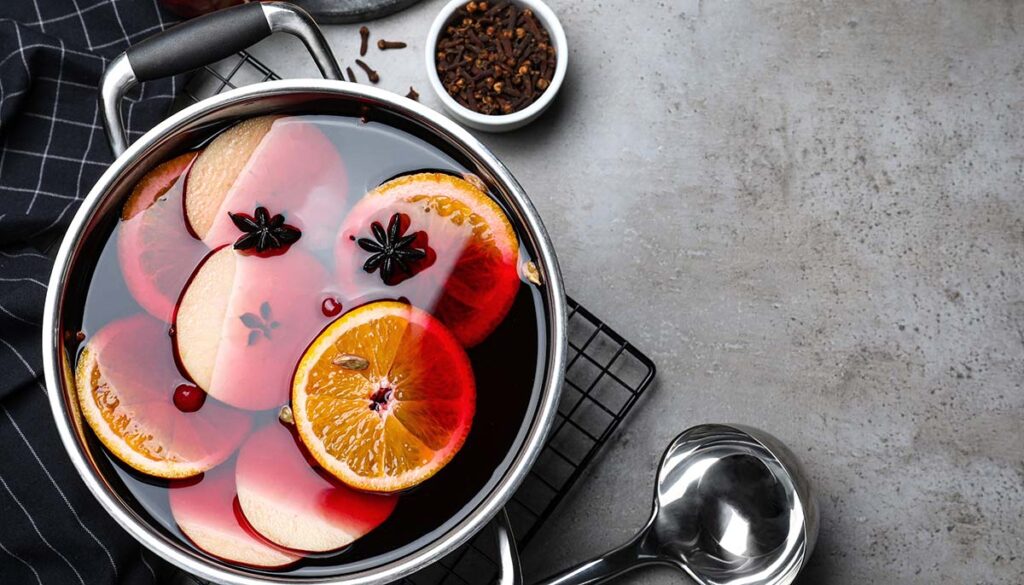 mulled wine and ingredients on grey table,