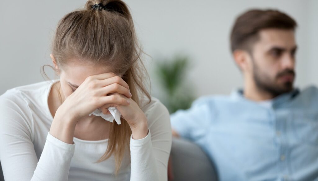 woman crying while man looks uninterested