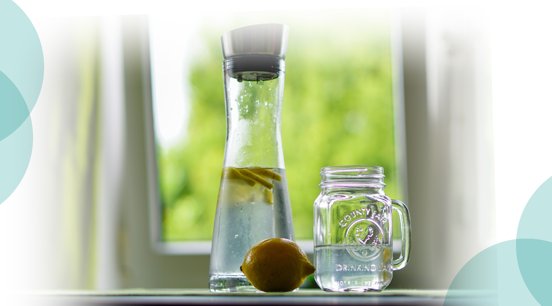 Jug and glass of water with lemons