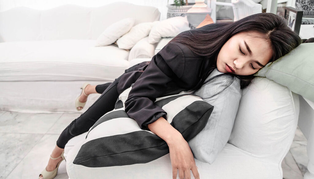 Businesswoman passed out on her couch after work