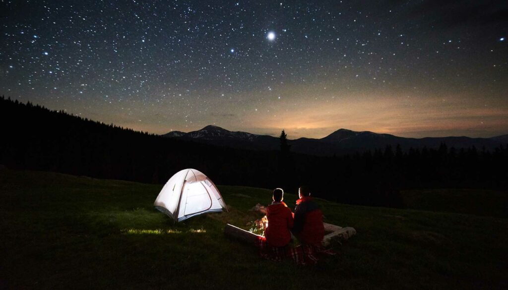 two people camping, tent, looking at night sky, stars