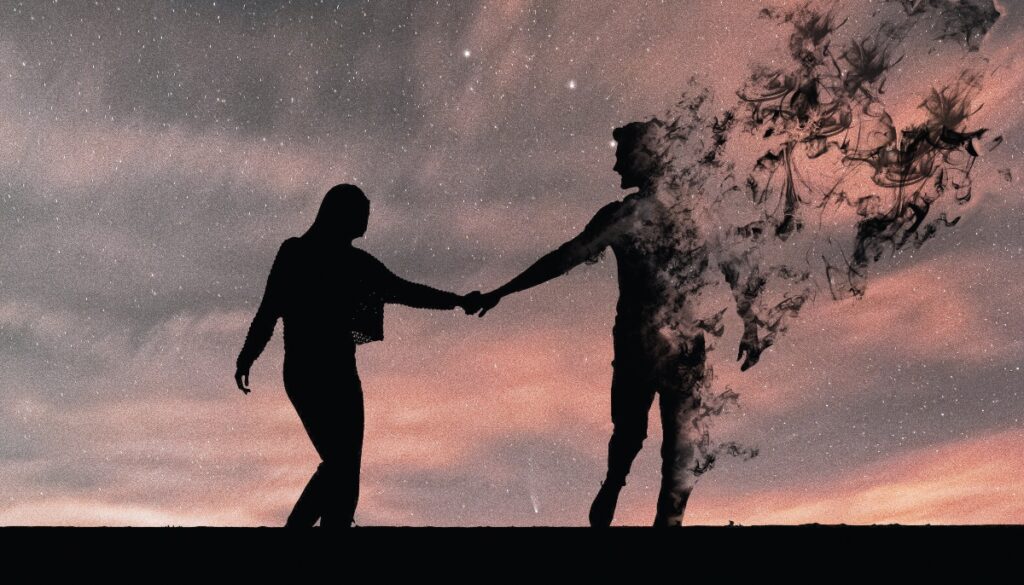 couple holding hands as one disintegrates and floats away
