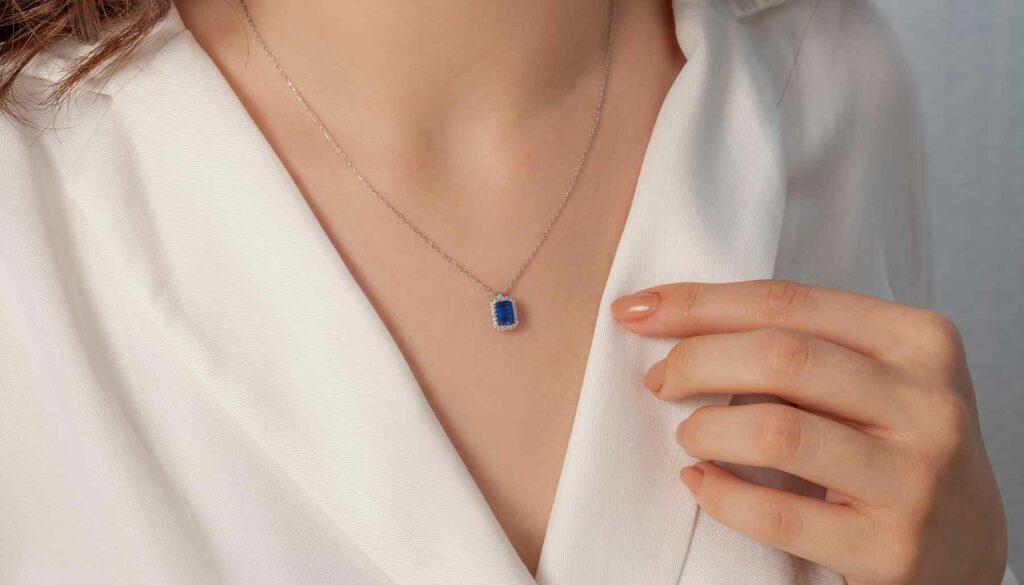 close up of a woman wearing a necklace with a blue stone in it