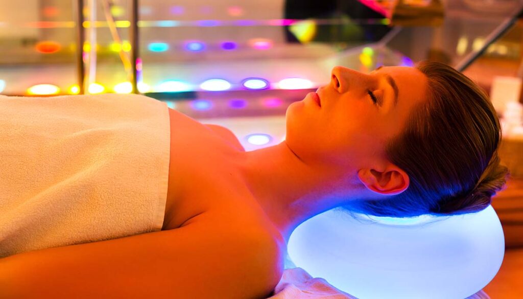 Woman enjoying therapy in spa with color therapy