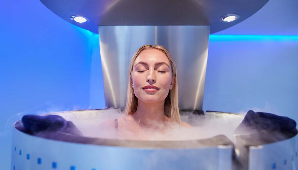 woman in a whole body cryotherapy cabin with her eyes closed. 