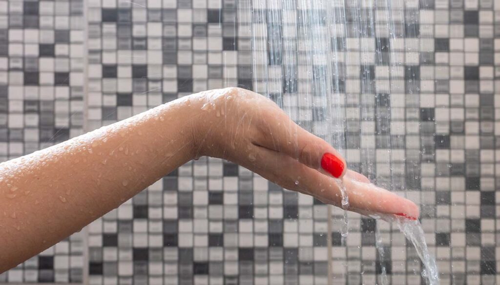 woman testing water temperature in shower