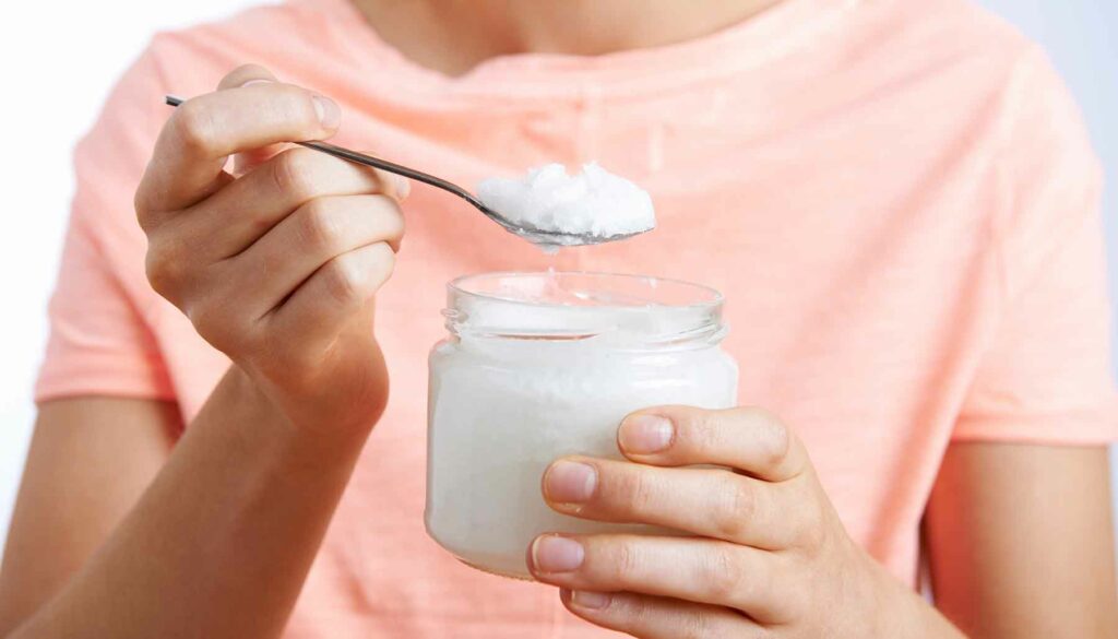 woman holding a jar of coconut oil