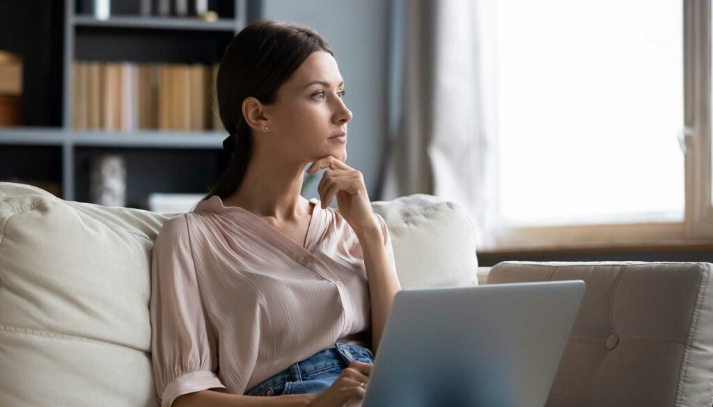 woman with her laptop, looking off to the side