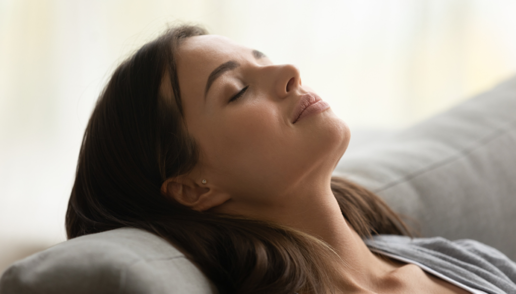 Woman relaxing on couch with eyes closed