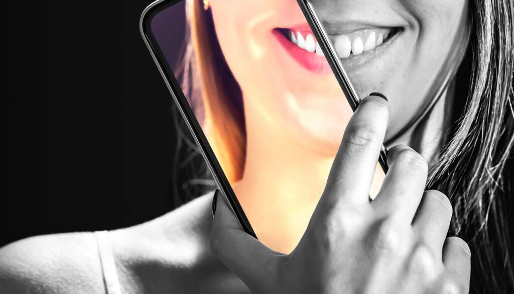 woman holding smart phone showing filtered face and real face