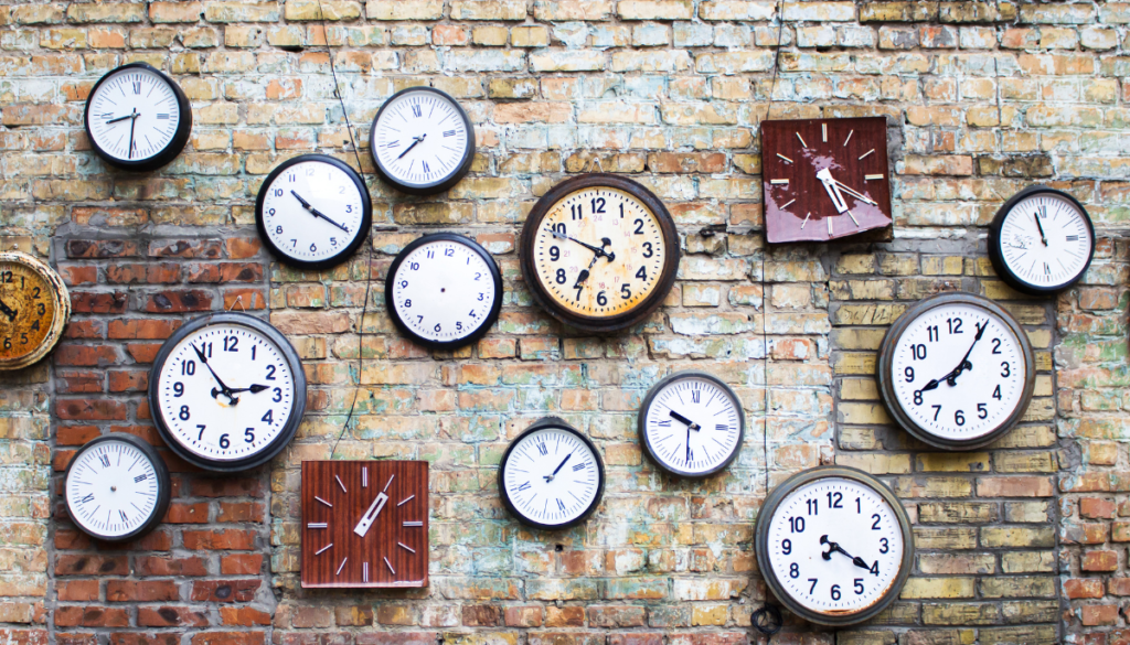 A brick wall featuring many clocks