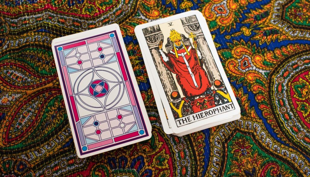 the hierophant card next to a deck of cards