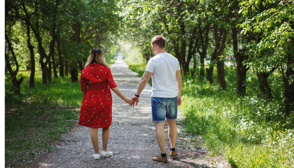 Young couple holding hands and walking in gardens