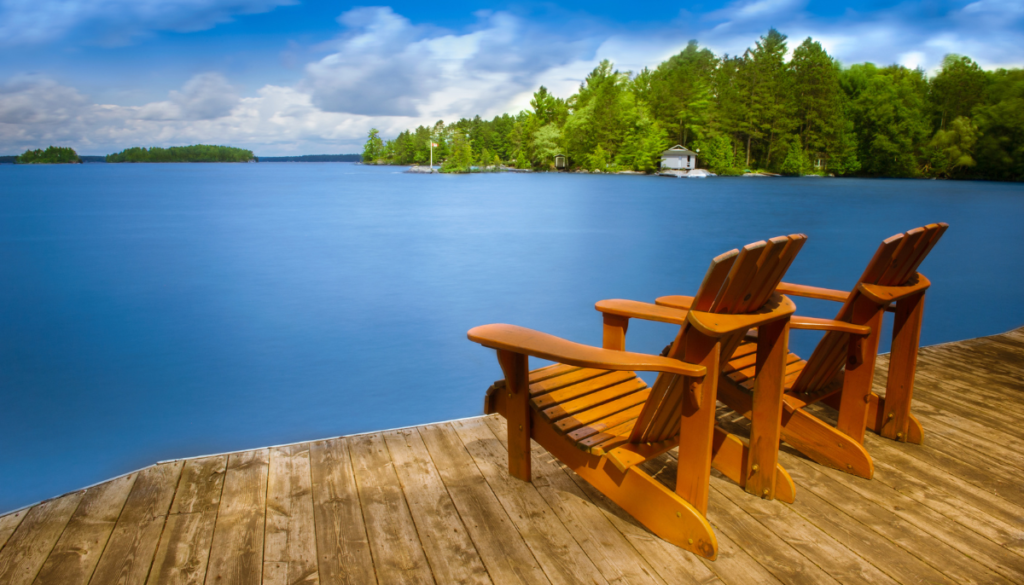 Two Adirondack chairs overlooking lake