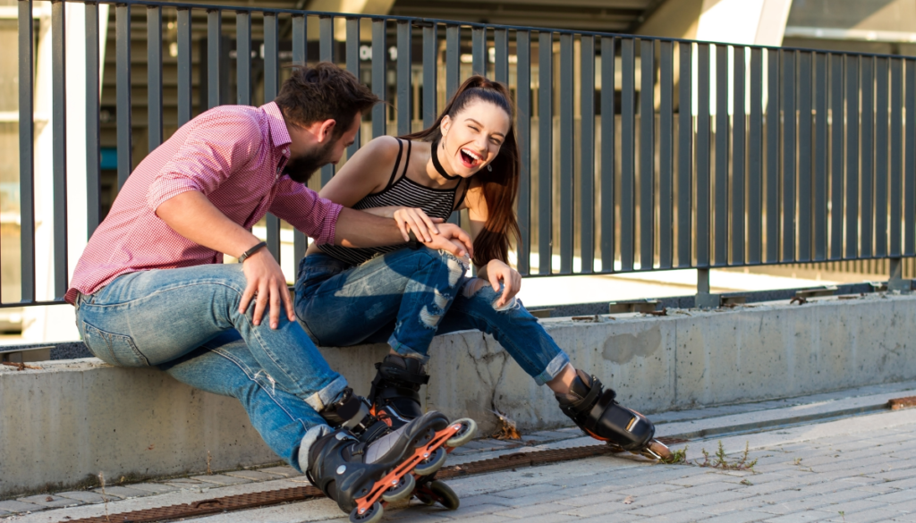 Couple wearing rollerblades laughing together