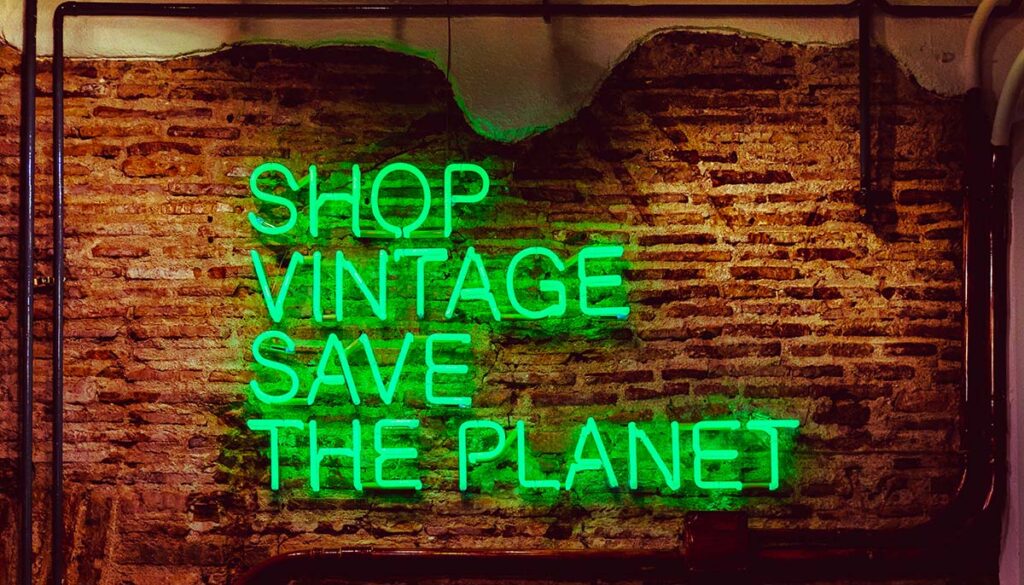 neon sign that reads "shop vintage save the planet"