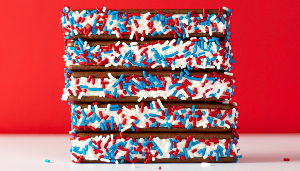 Ice cream sandwiches dipped in red white and blue sprinkles