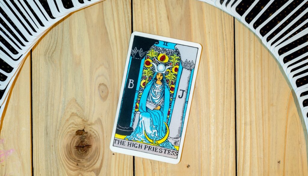 the high priestess card under a deck of cards