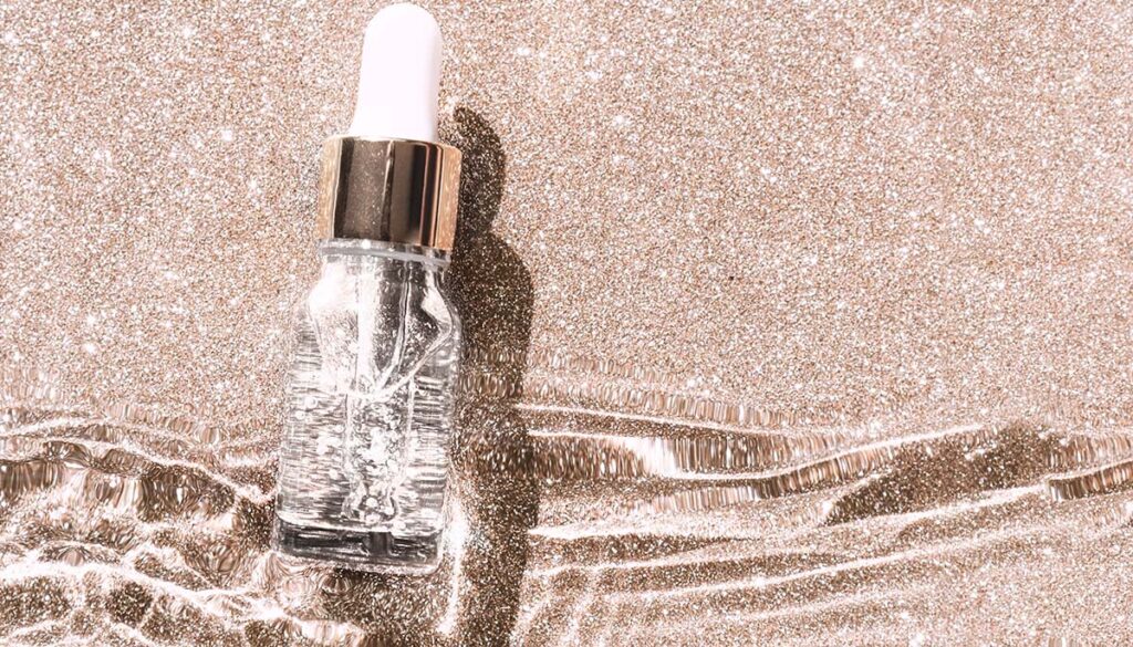 serum with collagen and peptides in glass bottle with dropper on golden background.
