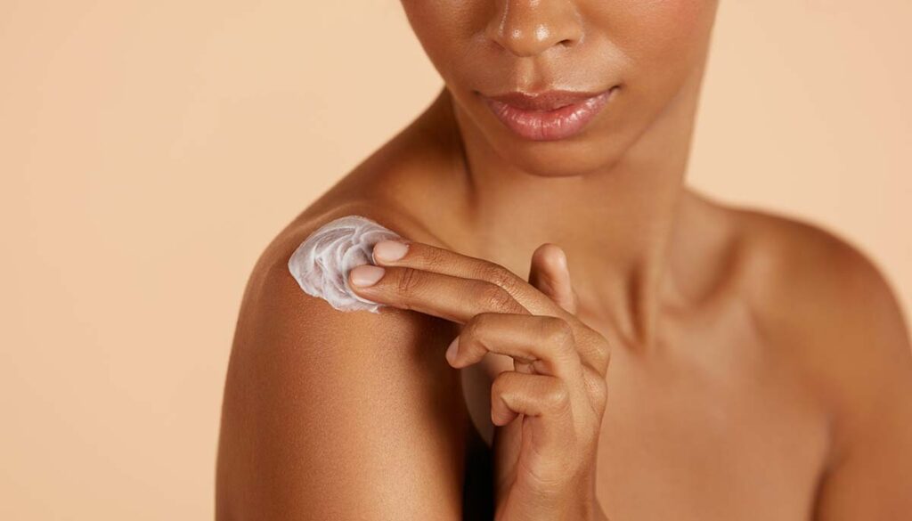 Closeup woman's body with cosmetic cream on skin