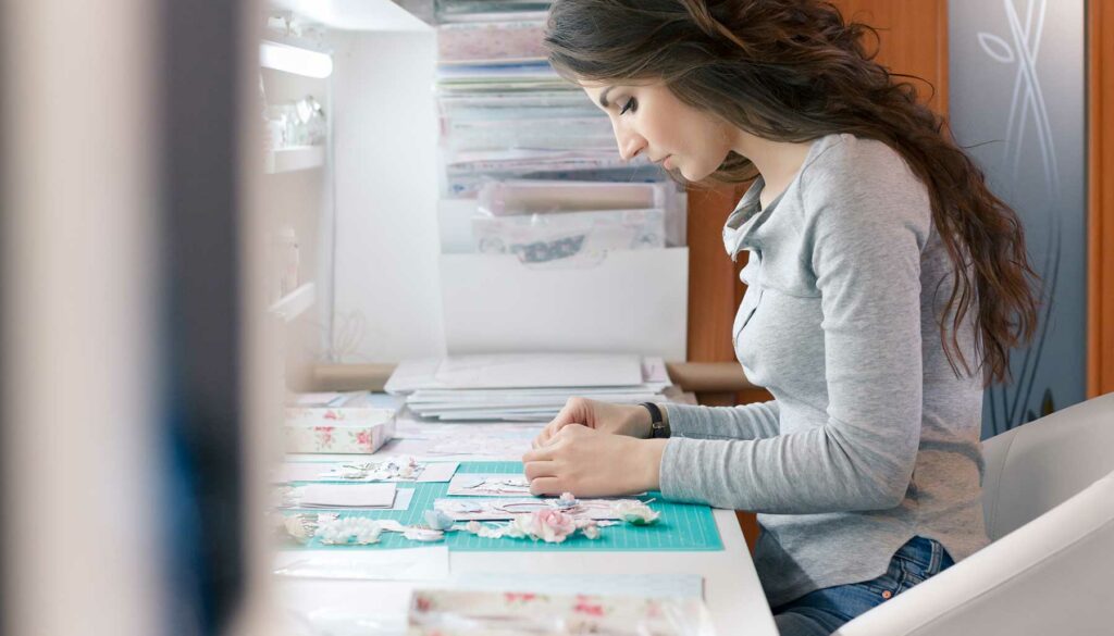 woman at table in craft room scrapbooking