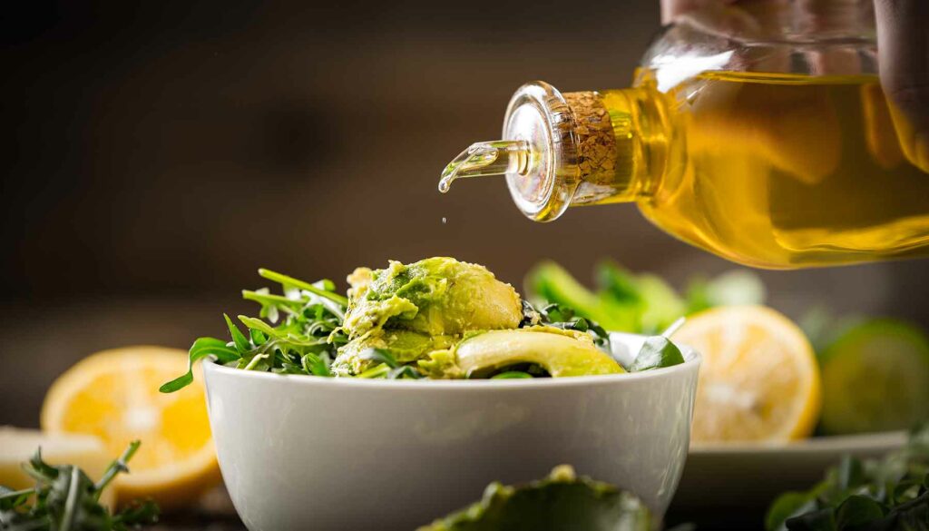 pouring avocado oil on salad