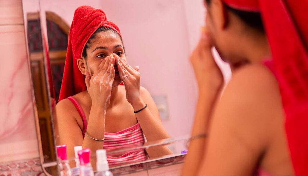 woman doing skincare routine in the mirror after shower