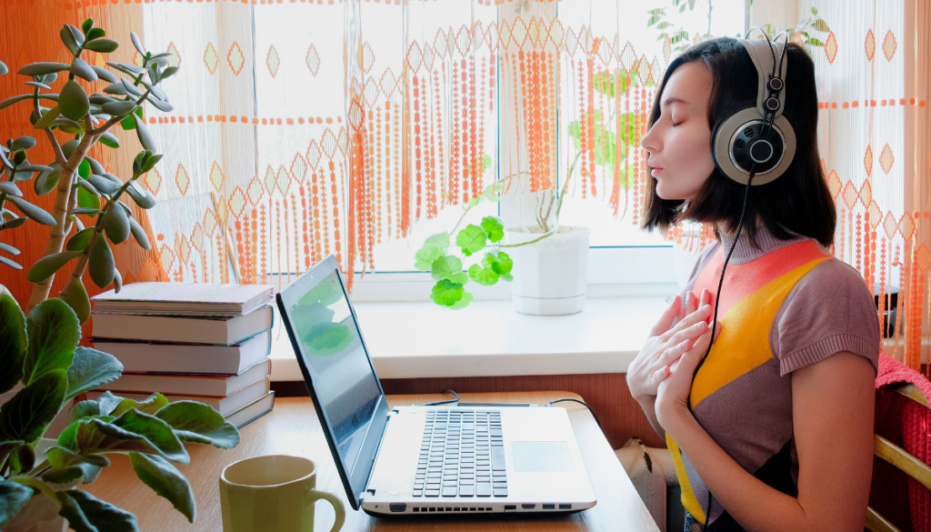 Woman with headphones on talking to laptop