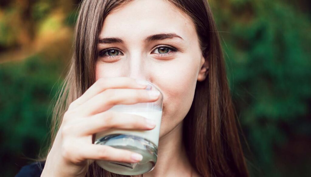 young woman drinking glass of milk 