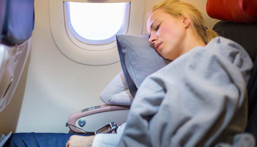 woman attempting to nap on a flight