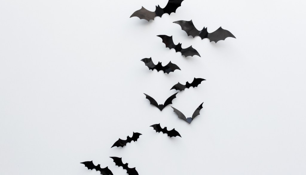 Black paper bats on white wall