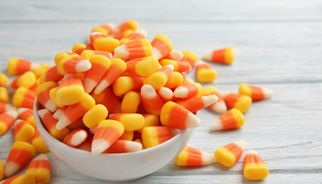 Bowl of candy corn on white wood
