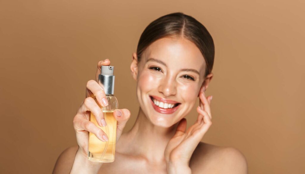 smiling woman holding oil cleanser on tan backdrop