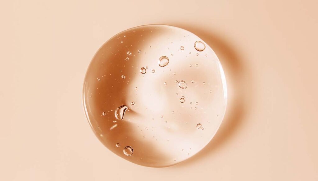 Cosmetic serum gel beauty oil drop on color background. 