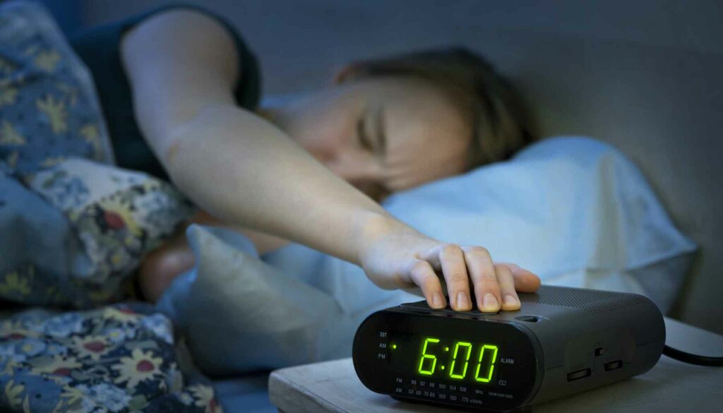 Woman pressing snooze button