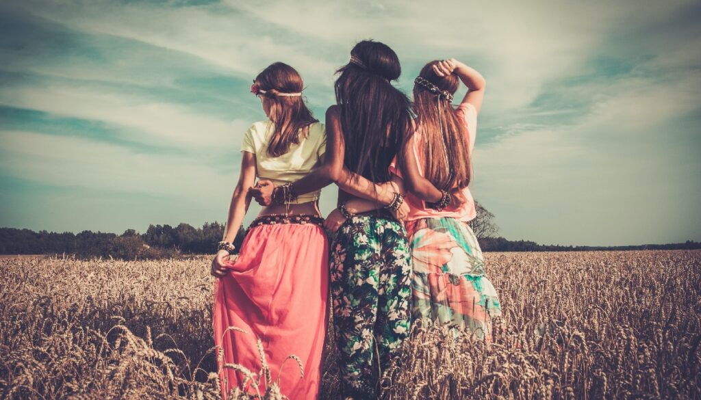 three hippie women standing in a field