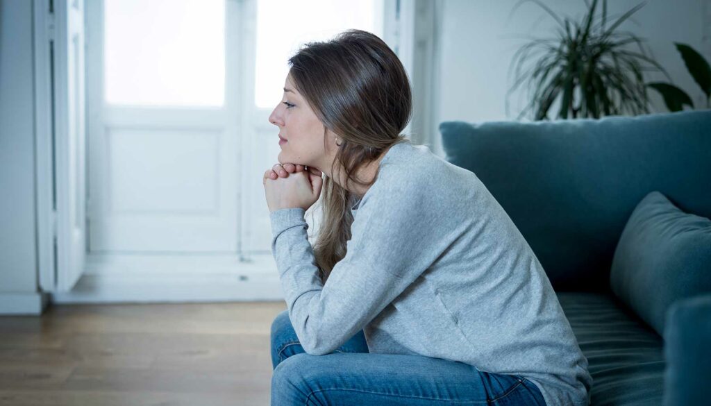woman sitting on couch, depressed or sad