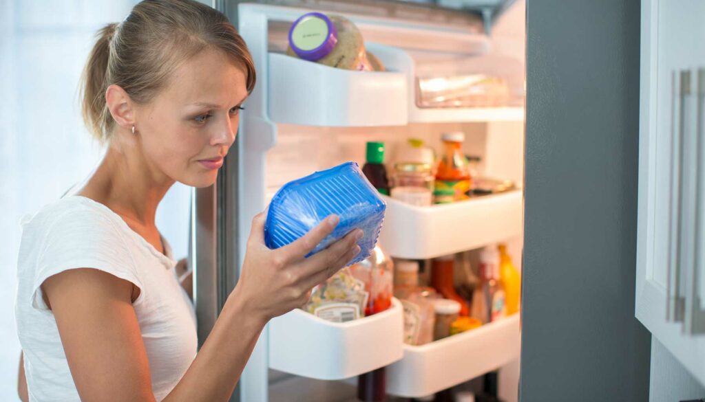 woman looking at food expiration date