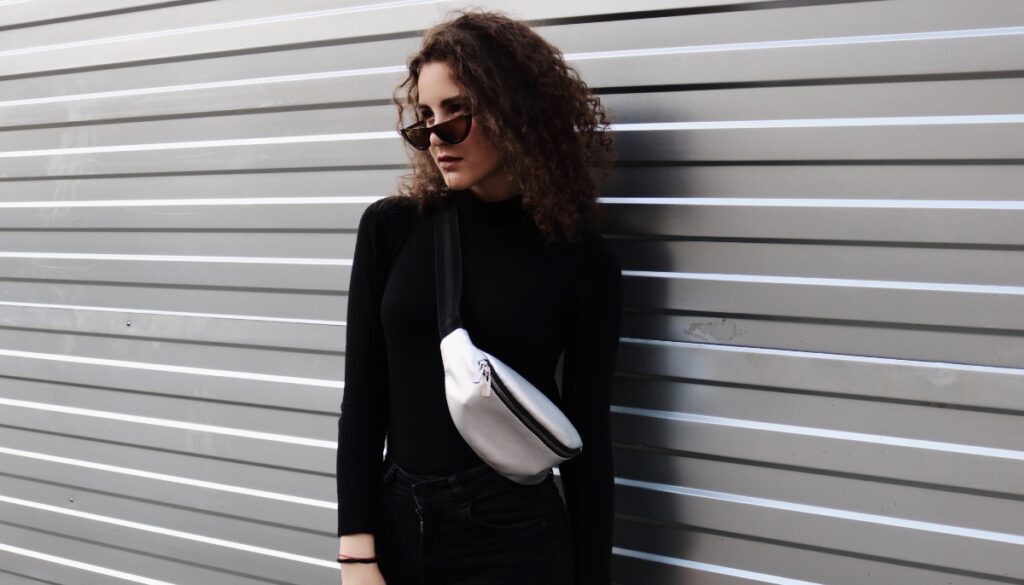 woman dressed in black with sunglasses and fanny pack