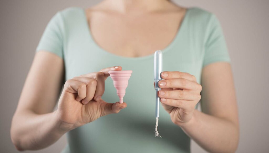 woman holding tampon and menstrual cup